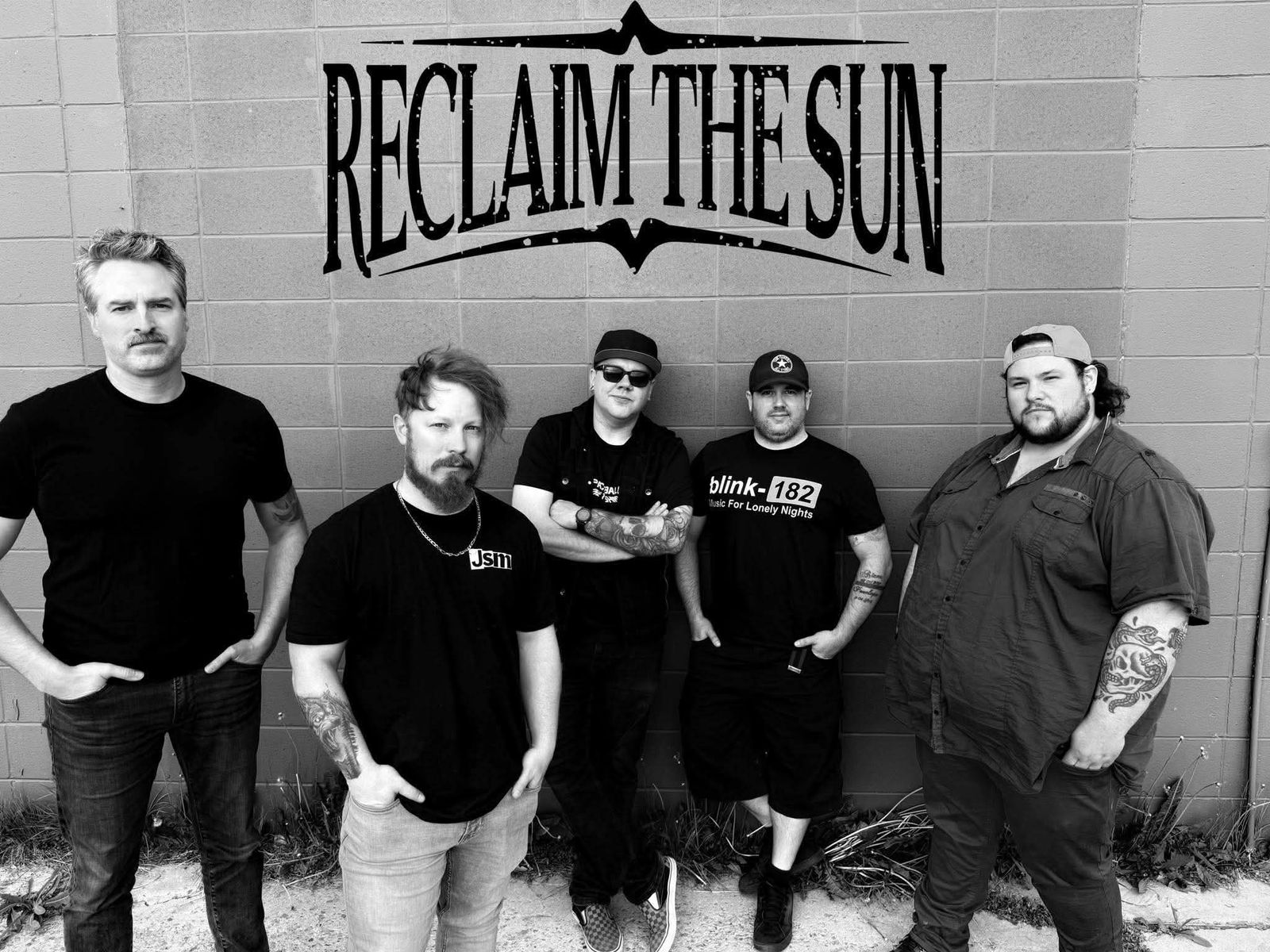 The five members of Reclaim The Sun in black and white against a block wall